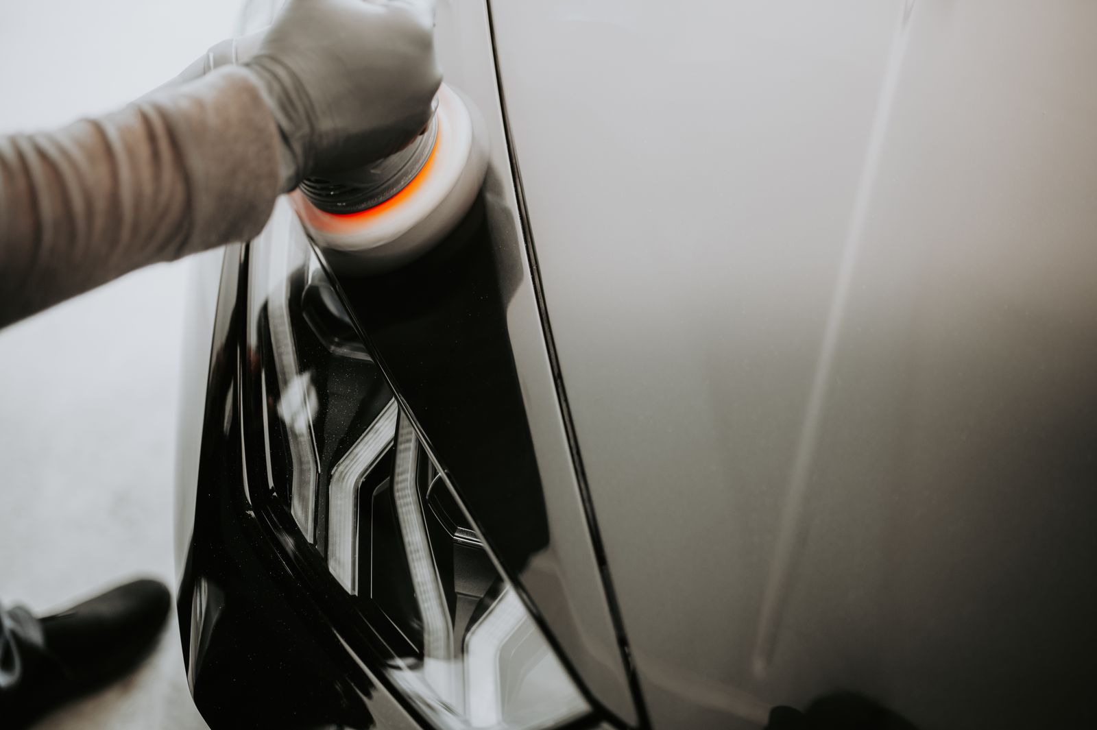 Detailer polishing a car panel to a mirror finish